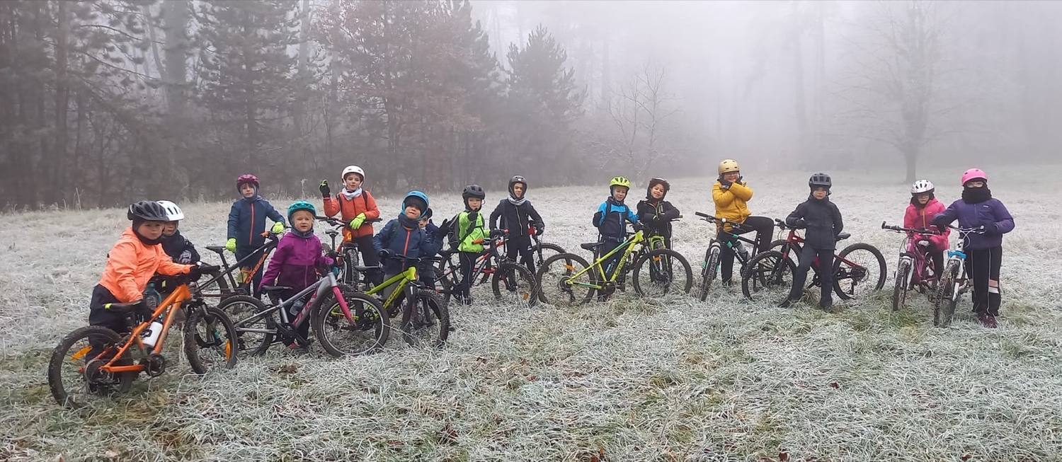 École VTT : enfants alignés avec leurs vélos dans un pré givré